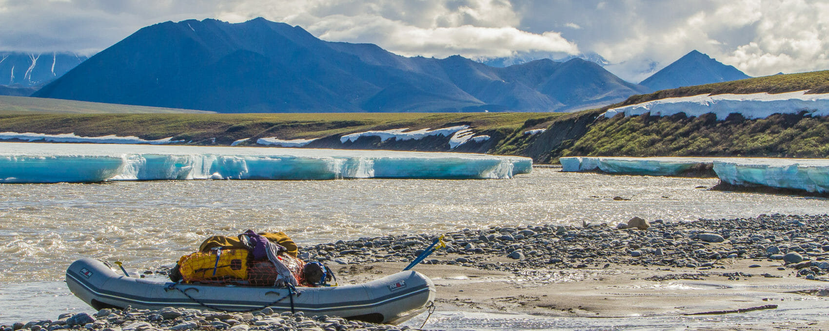 a raft is parked on an arctic refuge river with aufeis on the shore