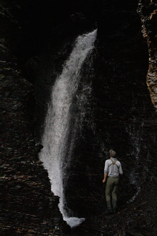A hiker visits a waterfall in Gates of the Arctic National Park on an Arctic Wild backpacking trip.